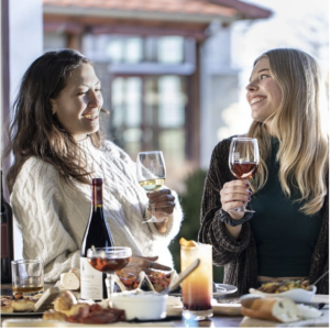 2 women enjoying wine at Cedar Ridge winery outside